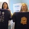 Two volunteers help pass out t-shirts