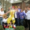 Volunteers pose around a statue of Ronald McDonald